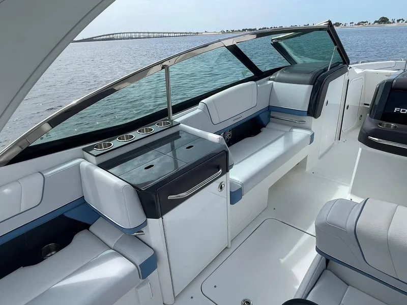 Slide: The Image of 2023 Formula 330 Crossover Bowrider OB interior with seating and cup holders, overlooking water. - 31