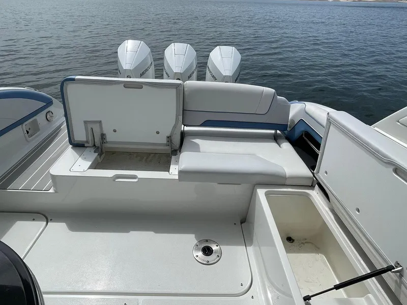 Slide: The Image of 2023 Formula 330 Crossover Bowrider OB, spacious seating, and storage, on calm water. - 38