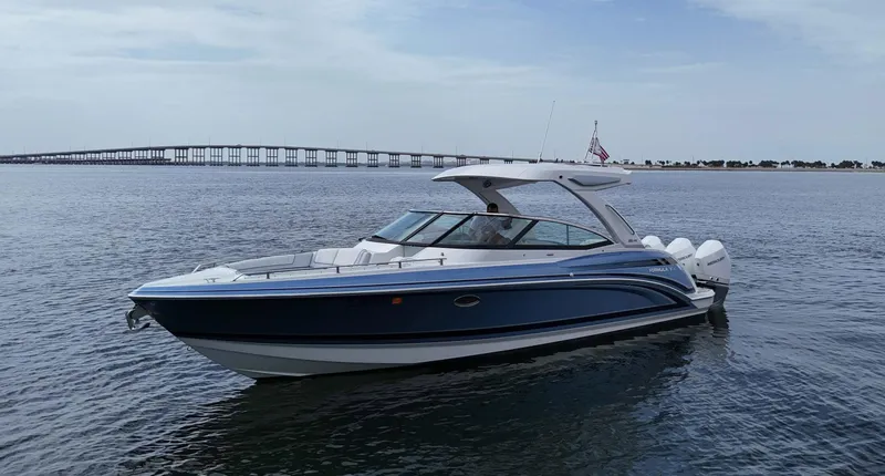 Slide: The Image of 2023 Formula 330 Crossover Bowrider OB on calm water with bridge in background. - 4