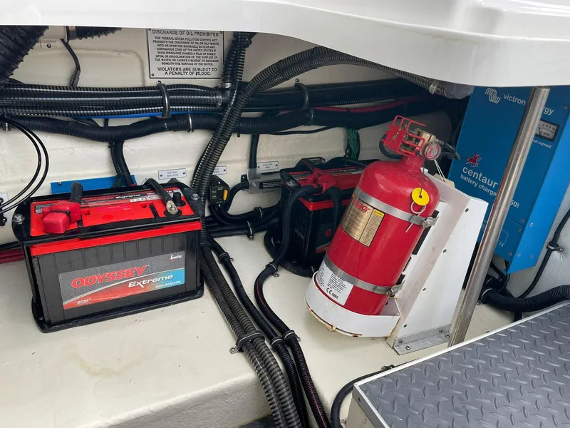 Slide: The Image of 2023 Formula 330 Crossover Bowrider OB engine compartment with battery and fire extinguisher. - 42