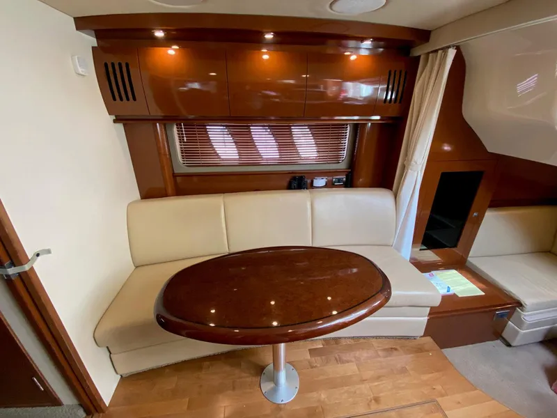 Slide: The Image of Interior of 2008 Sea Ray 38 Sundancer with wooden table and cream seating. - 13