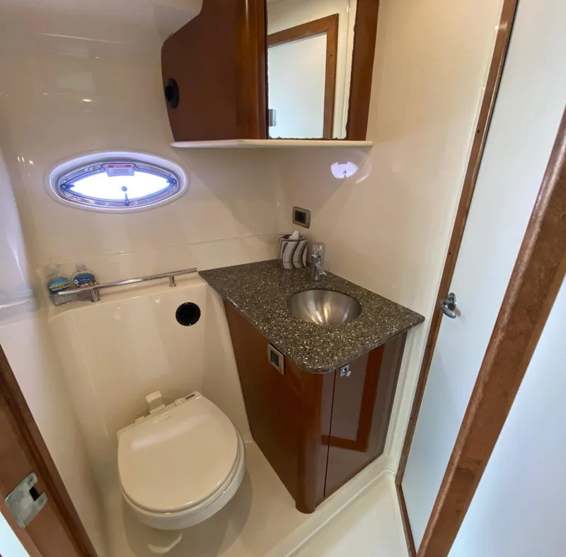 Slide: The Image of 2008 Sea Ray 38 Sundancer bathroom with sink, toilet, and porthole window. - 9