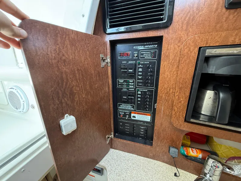 Slide: The Image of 2008 Hydra-Sports Vector 3500 VX electrical panel with open wooden cabinet door. - 9