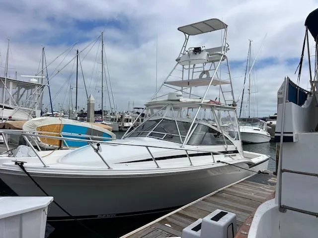 The Image of 1997 Blackfin 30.7 EXPRESS boat docked at marina with tower and clear skies. - 1
