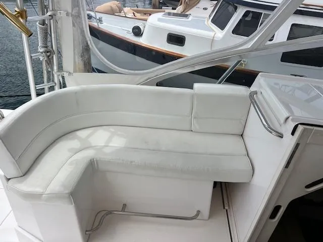 Slide: The Image of White seating area on a 1997 Blackfin 30.7 EXPRESS boat, docked near another vessel. - 12