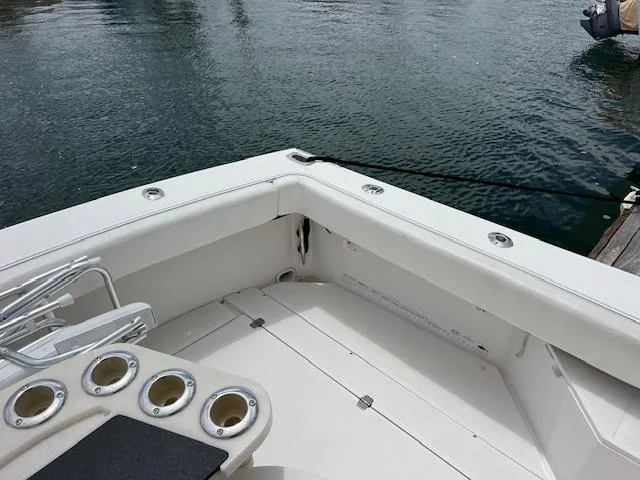 Slide: The Image of 1997 Blackfin 30.7 EXPRESS boat deck with rod holders, docked on calm water. - 16