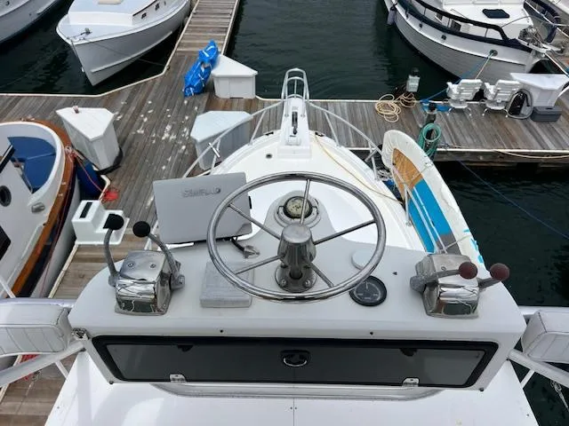 Slide: The Image of Helm of 1997 Blackfin 30.7 EXPRESS boat docked at marina, featuring steering wheel and controls. - 22