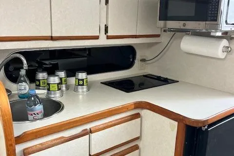 Slide: The Image of 1997 Blackfin 30.7 EXPRESS boat kitchen with sink, stove, and microwave. - 29