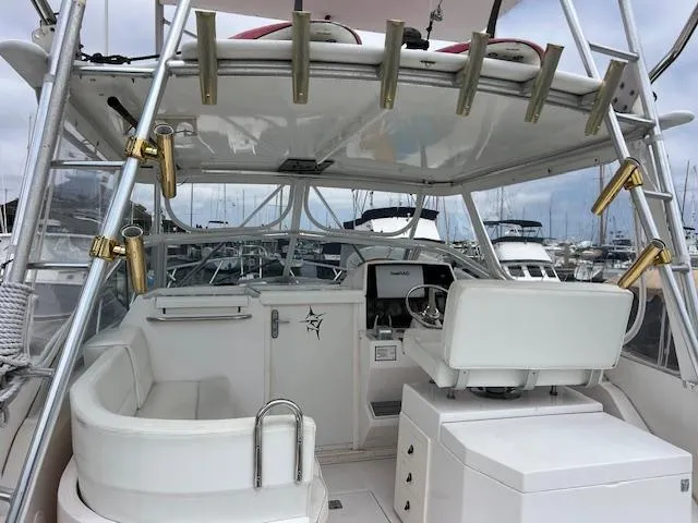 Slide: The Image of 1997 Blackfin 30.7 EXPRESS boat interior with helm, seating, and rod holders. - 3