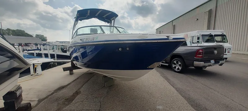 Slide: The Image of 2021 Monterey M4 boat in marina, blue and white hull, parked near vehicles. - 3