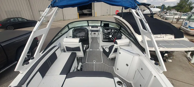 Slide: The Image of 2021 Monterey M4 boat interior with seating and steering wheel, docked at a marina. - 5