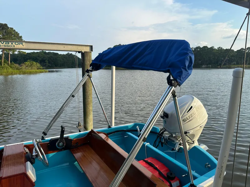 Slide: The Image of 1968 Boston Whaler 13 Sport boat with blue cover and Suzuki outboard motor on a calm lake. - 3