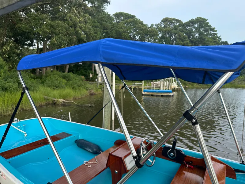 Slide: The Image of 1968 Boston Whaler 13 Sport boat with blue canopy on a calm lake. - 4