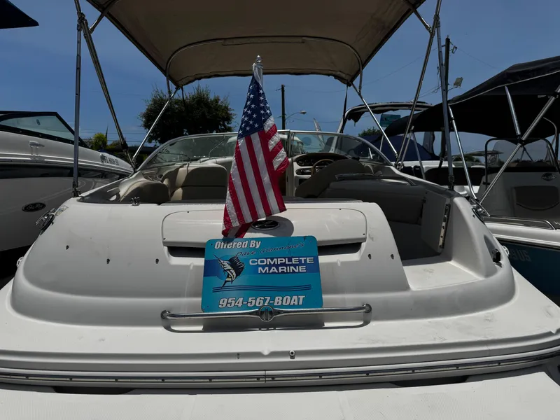 The Image of 2001 Sea Ray 240 Sundeck boat with American flag and Complete Marine sign. - 1