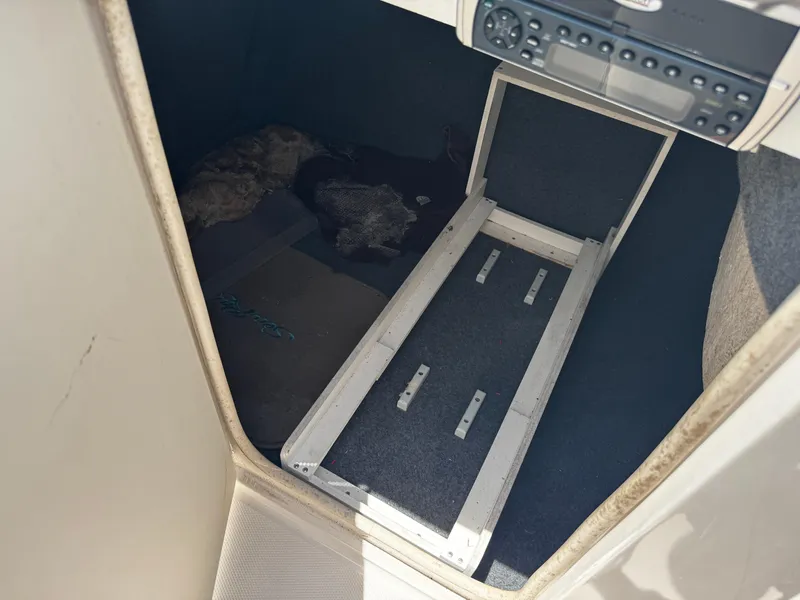 Slide: The Image of 2001 Sea Ray 240 Sundeck interior storage compartment with radio and carpeted flooring. - 10