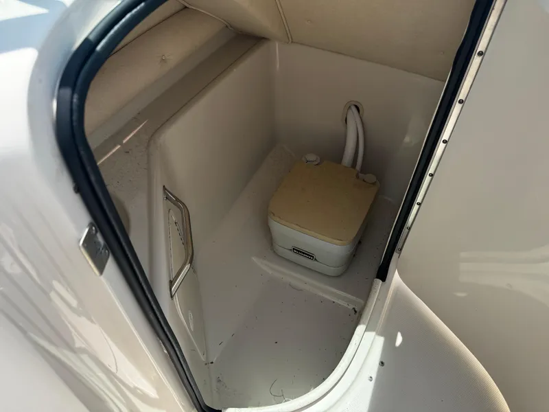 Slide: The Image of Portable toilet inside 2001 Sea Ray 240 Sundeck boat compartment. - 11