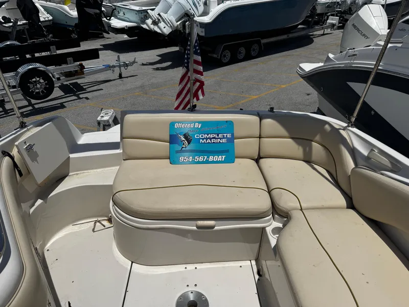 Slide: The Image of 2001 Sea Ray 240 Sundeck boat interior with beige seating and American flag. - 8