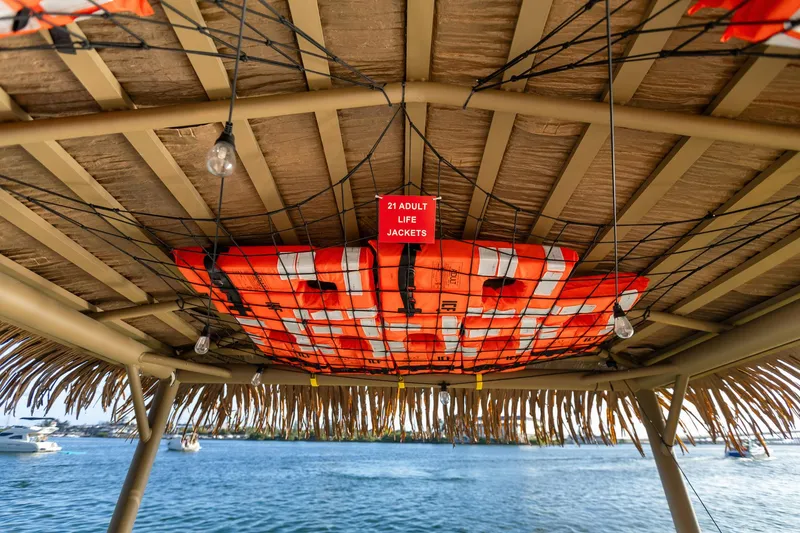 Slide: The Image of Tiki hut ceiling with life jackets, Beachcat 26 Tiki COI, 2023 model, by the water. - 10