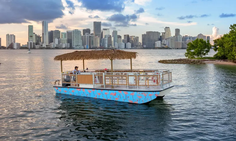 Slide: The Image of 2023 Beachcat 26 Tiki COI boat cruising near city skyline at sunset. - 18