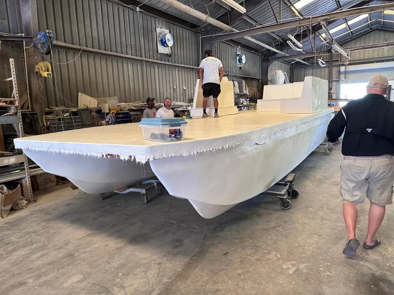 Slide: The Image of 2023 Beachcat 26 Tiki COI catamaran under construction in a workshop. - 22
