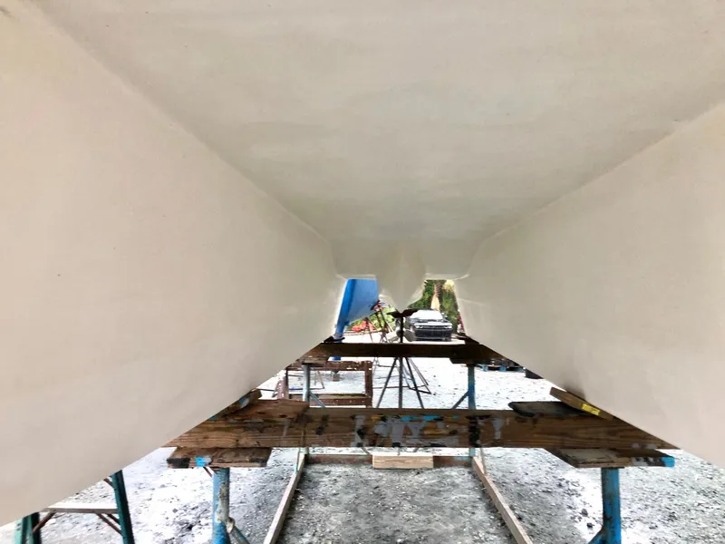 Slide: The Image of Underneath view of 2023 Beachcat 26 Tiki COI catamaran on supports. - 23