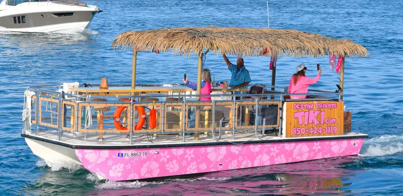 Slide: The Image of Tiki-themed Beachcat 26 Tiki COI boat cruising on water, 2023 model, with passengers enjoying the ride. - 29