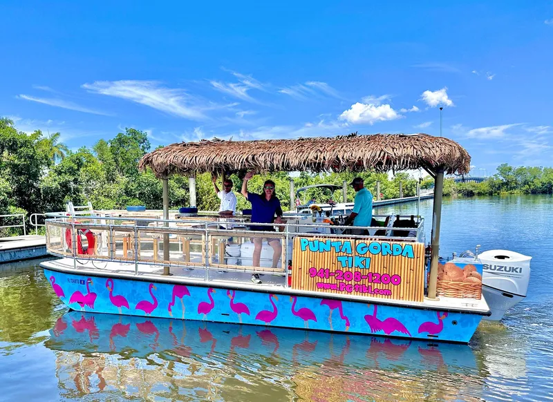 Slide: The Image of 2023 Beachcat 26 Tiki COI boat with tiki roof and flamingo design on a sunny day. - 32
