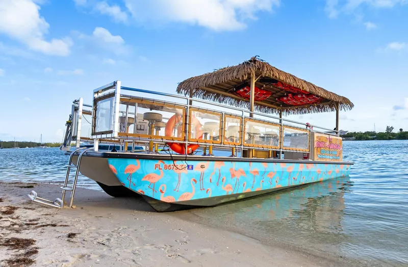Slide: The Image of 2023 Beachcat 26 Tiki COI boat with tropical design on sandy beach. - 4