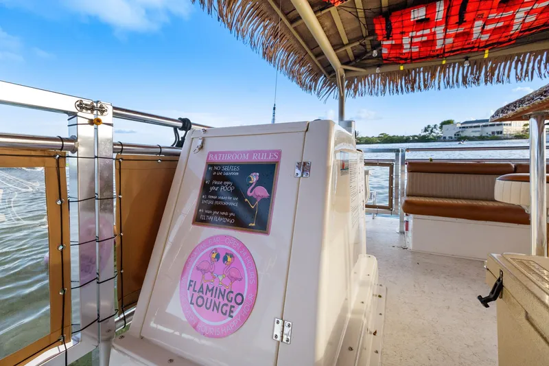 Slide: The Image of Tiki-themed boat interior with "Flamingo Lounge" sign, Beachcat 26 Tiki COI, 2023 model. - 9