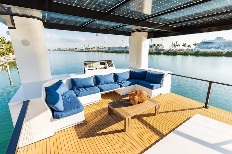 Slide: The Image of Luxurious Arkup 50 yacht deck with blue seating, solar panels, and waterfront view, 2025 model. - 10