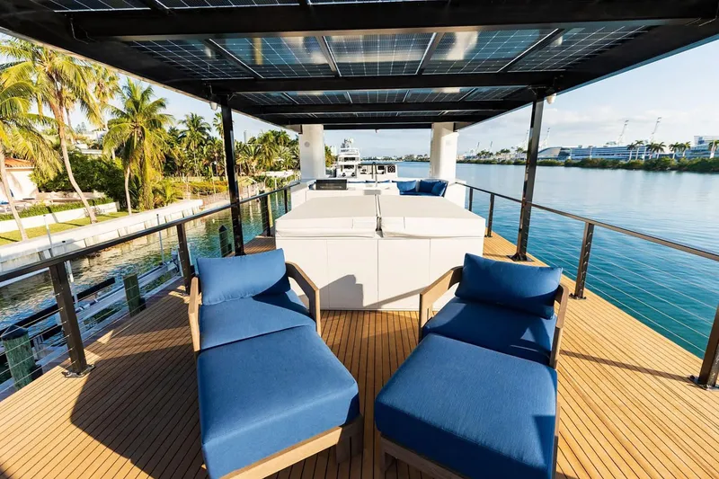Slide: The Image of Luxury Arkup 50 yacht deck with blue loungers, solar panels, and waterfront view, 2025 model. - 11