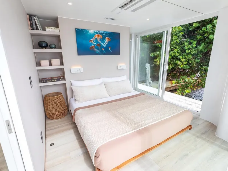 Slide: The Image of Modern bedroom in Arkup 50 houseboat, featuring a cozy bed and large window with greenery view. - 19