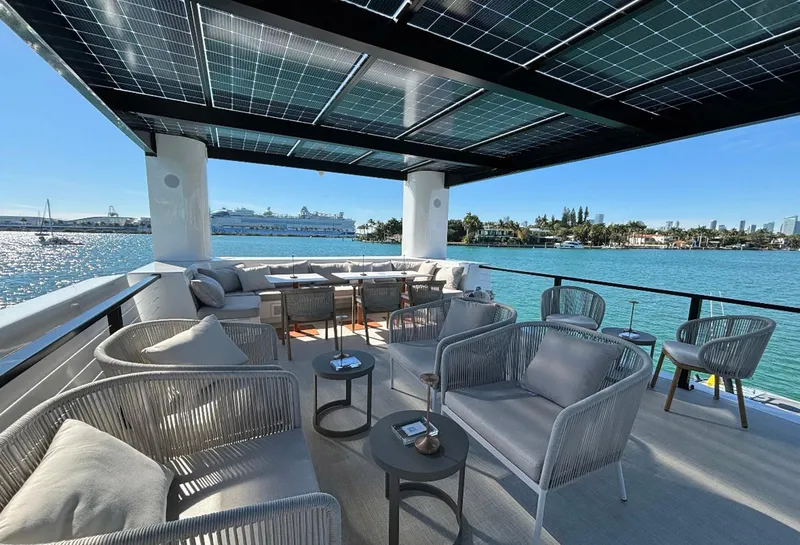 Slide: The Image of Luxurious Arkup 50 yacht deck with solar panels, modern seating, and waterfront view. - 6