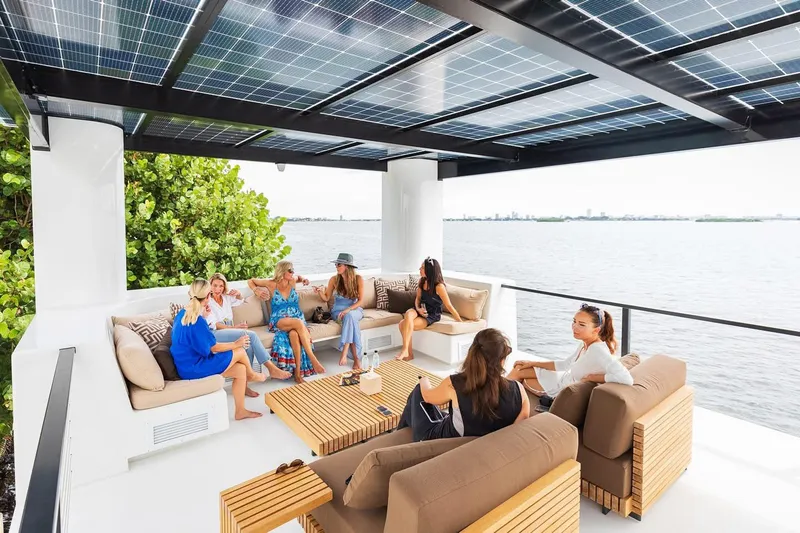 Slide: The Image of Group relaxing on Arkup 50 yacht's deck with solar panels, overlooking water. - 9