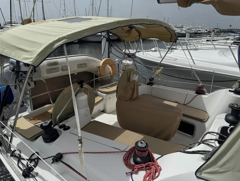 Slide: The Image of 2010 Jeanneau Sun Odyssey 39i Performance sailboat with beige canopy and seating in a marina. - 4