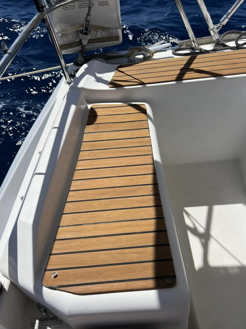 Slide: The Image of 2010 Jeanneau Sun Odyssey 39i Performance sailboat deck with wooden seating, ocean view. - 14