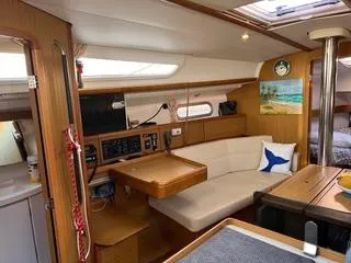 Slide: The Image of Interior of 2010 Jeanneau Sun Odyssey 39i Performance sailboat, featuring cozy seating and wooden finishes. - 21