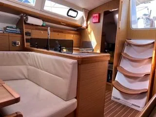 Slide: The Image of Interior of 2010 Jeanneau Sun Odyssey 39i Performance yacht, featuring cozy seating and wooden finishes. - 22