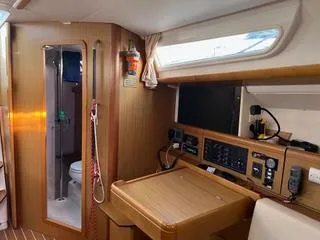 Slide: The Image of Interior of 2010 Jeanneau Sun Odyssey 39i Performance sailboat, featuring navigation station and bathroom. - 24