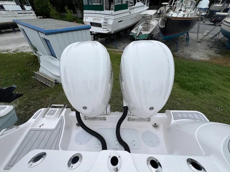 Slide: The Image of 2025 Sea Fox 288 Commander with dual outboard engines in a boatyard setting. - 19