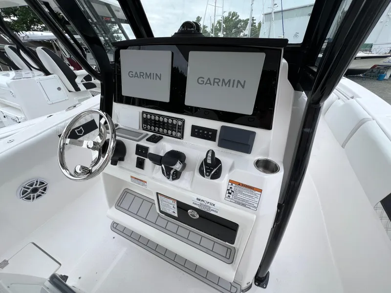 Slide: The Image of 2025 Sea Fox 288 Commander boat dashboard with dual Garmin displays and steering wheel. - 8