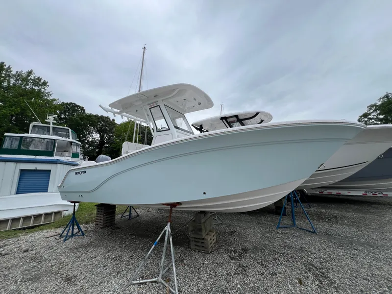 The Image of 2025 Sea Fox 228 Commander boat on display, elevated on stands, with overcast sky. - 0