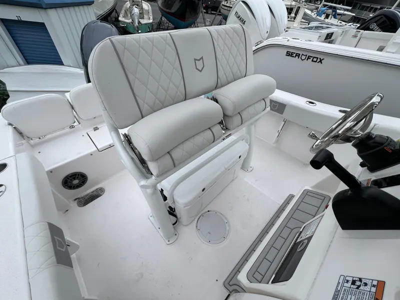 Slide: The Image of 2025 Sea Fox 228 Commander boat interior with cushioned seating and steering wheel. - 2