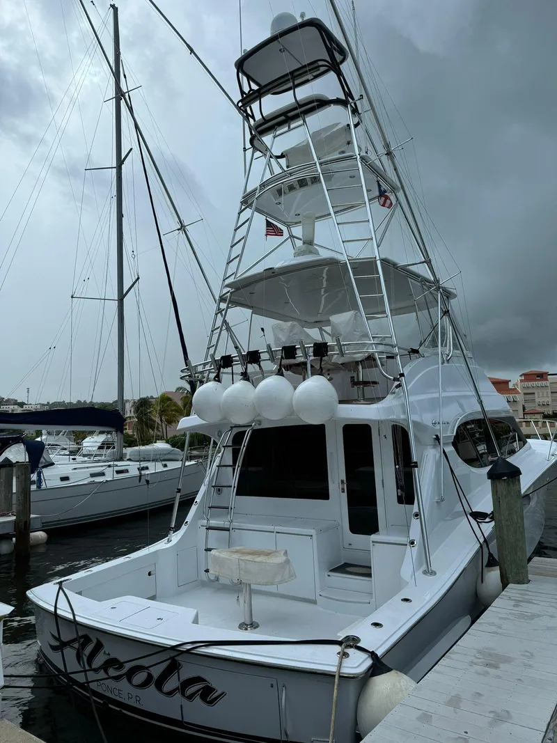 Slide: The Image of 2006 Hatteras 54 Convertible yacht docked at marina under cloudy sky. - 2