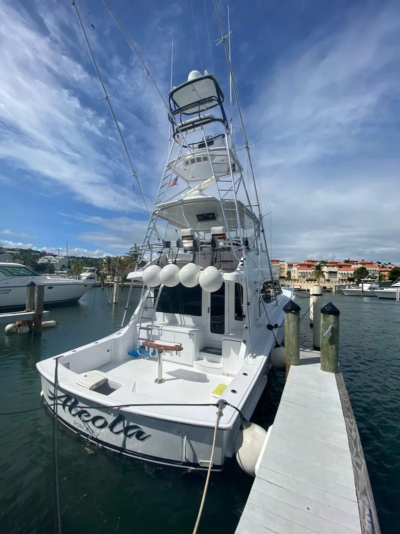 Slide: The Image of 2006 Hatteras 54 Convertible yacht docked at marina under blue sky. - 5