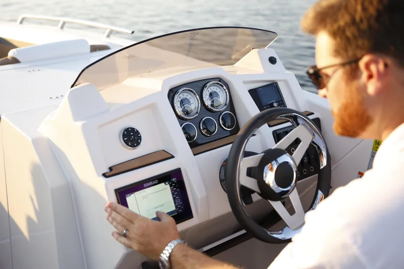 Slide: The Image of 2024 Starcraft SVX 231 OB DH boat dashboard with steering wheel and controls. - 5