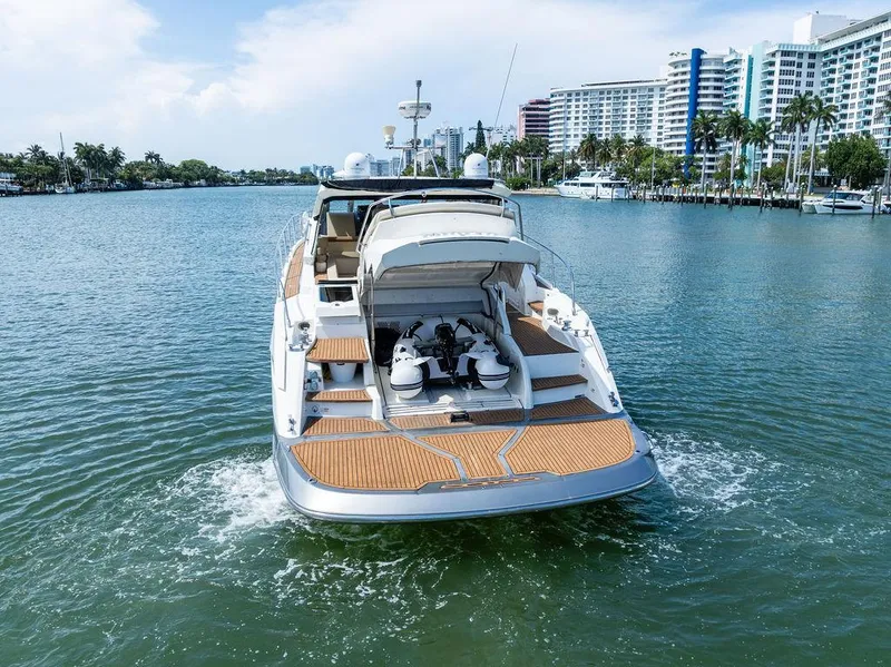 Slide: The Image of 2014 Cranchi 56 HT yacht cruising on a scenic waterway with city skyline. - 11