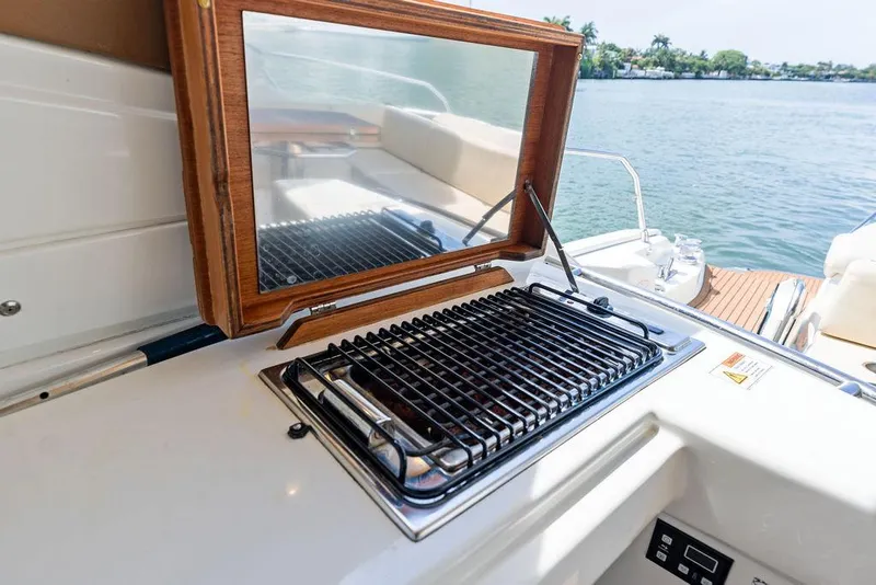 Slide: The Image of Outdoor grill on 2014 Cranchi 56 HT yacht, overlooking serene water and lush greenery. - 28