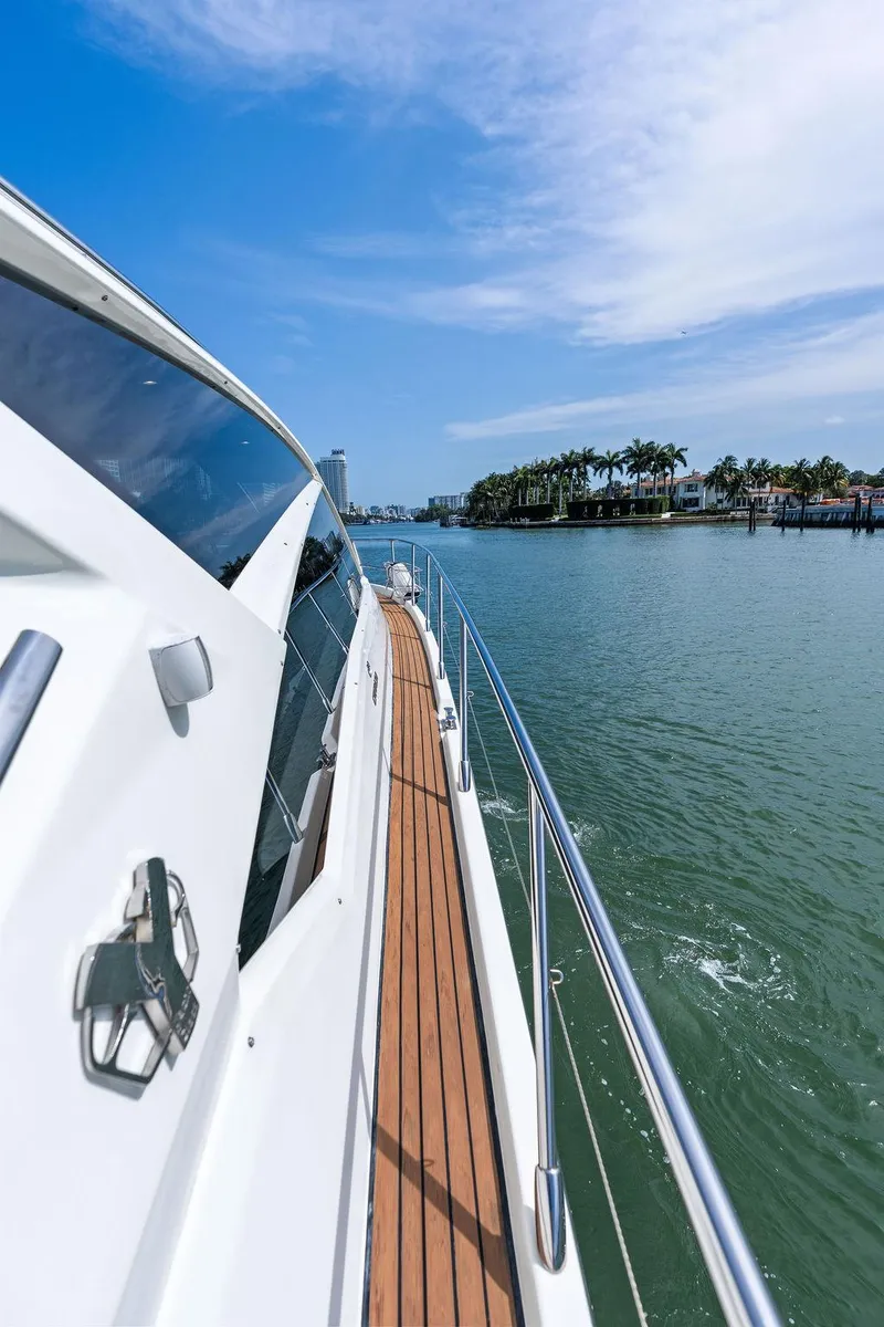 Slide: The Image of 2014 Cranchi 56 HT yacht cruising on a sunny day, showcasing sleek design and wooden deck. - 30