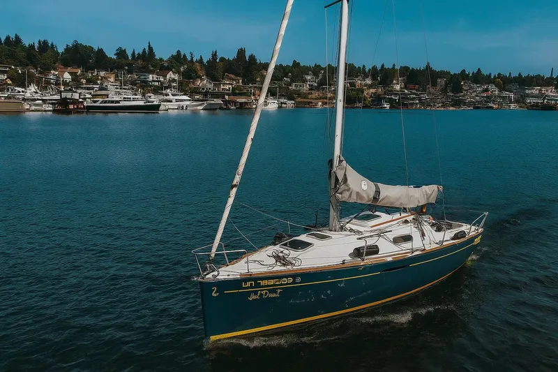 The Image of 2014 Beneteau FIRST 25 S sailboat on a serene lake with a scenic shoreline. - 0